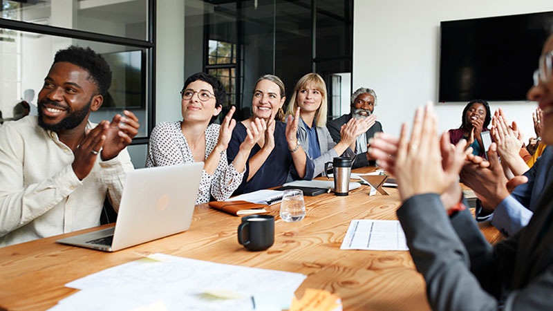 people clapping around a table