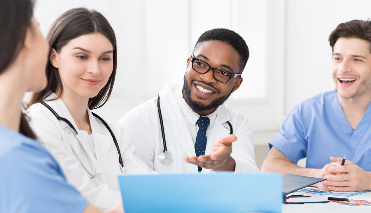 physicians sitting at a table and talking