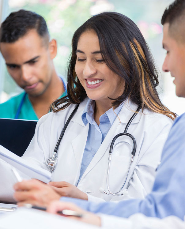 Female resident physician looking at report and smiling