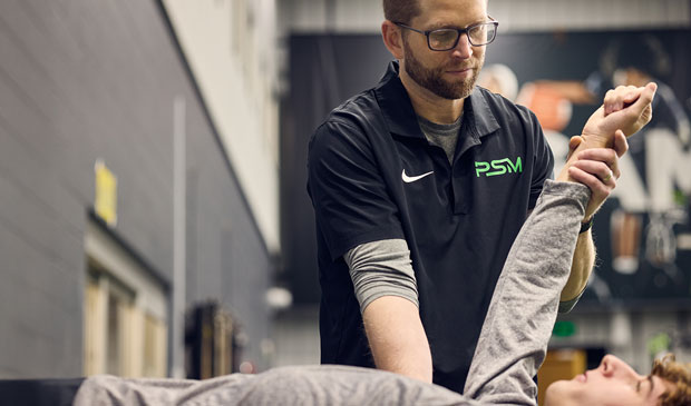 Sports physical therapist working with athlete