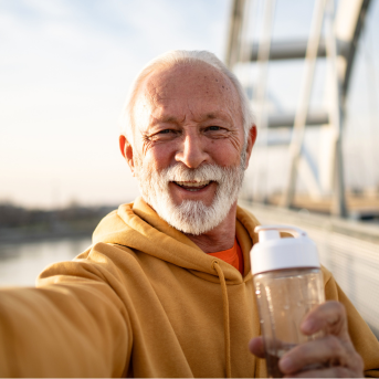Older gentleman smiling on a bridge