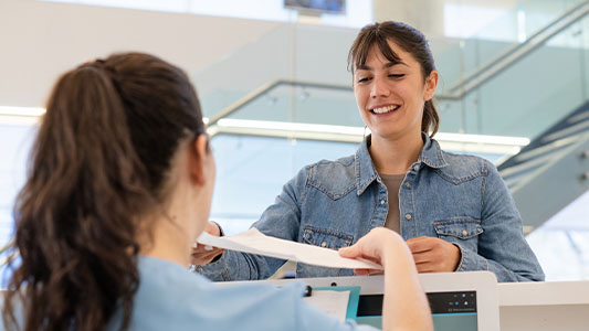 Patient handing paperwork in