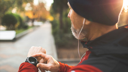 Man running and checking his fit watch