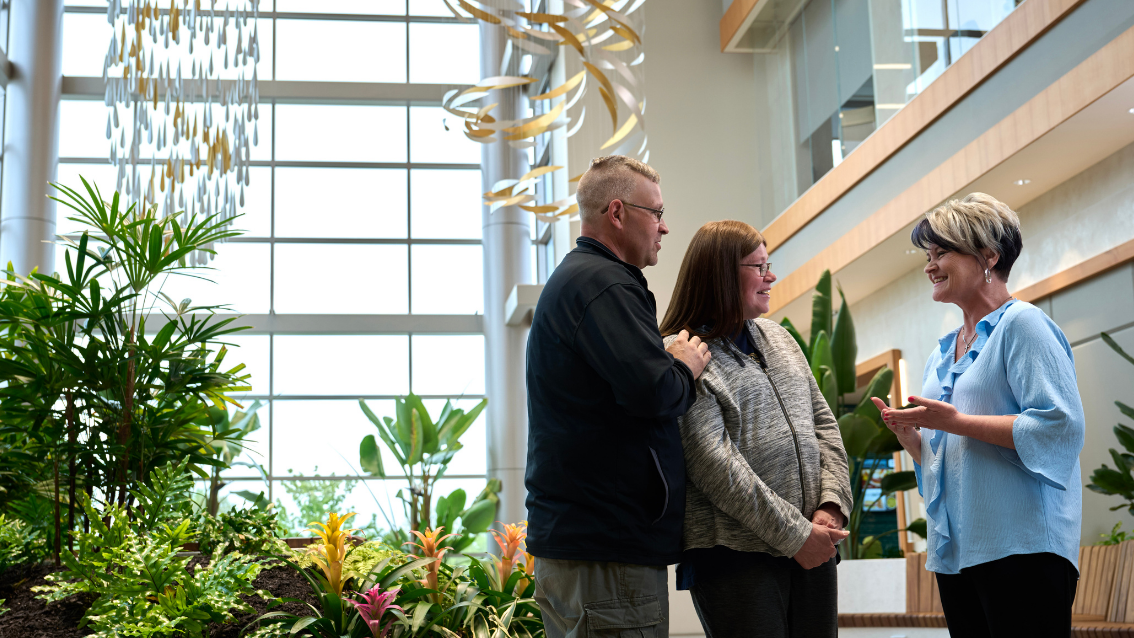Woman talking with two patients in cancer facility