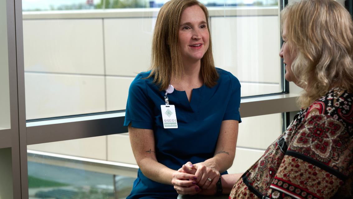 Woman doctor talking with patient and holding her hand
