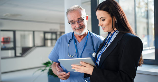 Doctor and rep talking while looking at an ipad