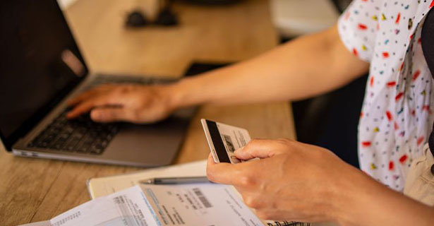 Person entering credit card information on laptop