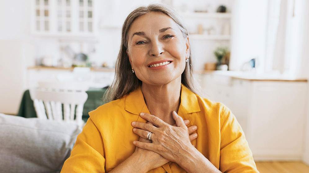 Older woman holding her hands on her heart