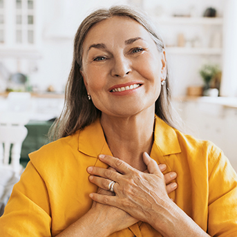Older woman holding her hands on her heart