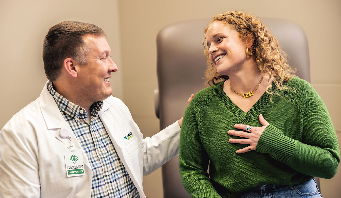 Doctor and patient talking with hand on heart