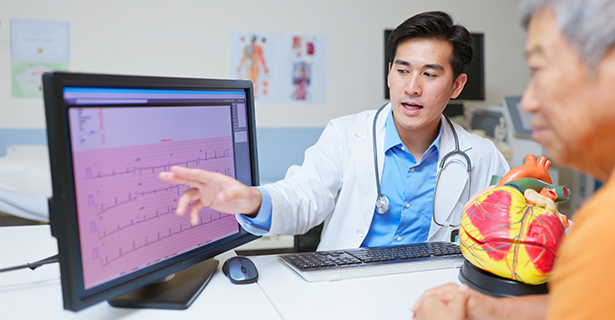 Doctor looking at test results while talking to patient