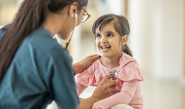 Doctor examining smiling child