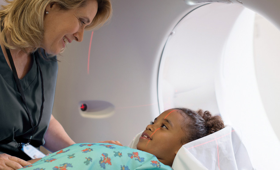 Imaging technician puts little girl in scanner