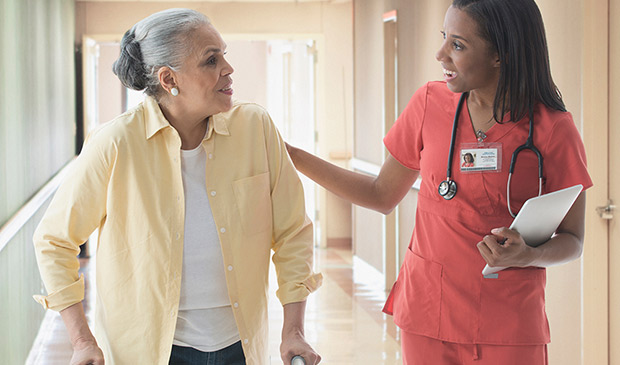 Nurse talking with patient in hospital hallway