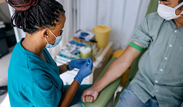 A phlebotomist prepares to take a sample